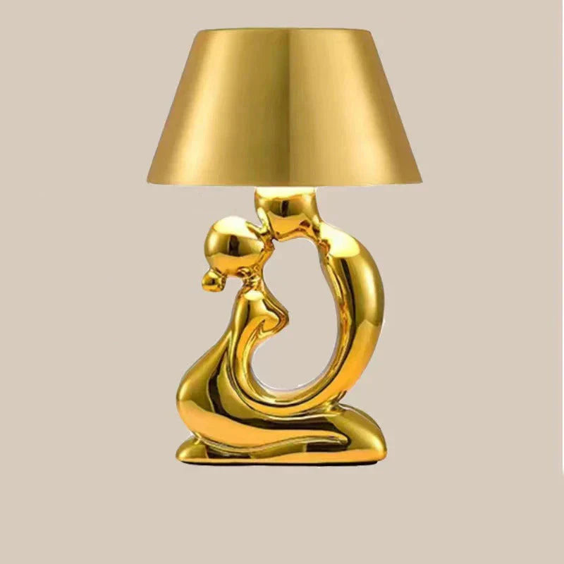 Tischleuchte mit skulpturalem Sockel in Form einer abstrakten Metallfigur und konischem Trommelschirm