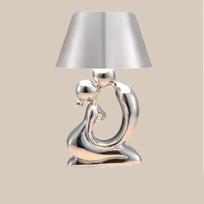 Tischleuchte mit skulpturalem Sockel in Form einer abstrakten Metallfigur und konischem Trommelschirm