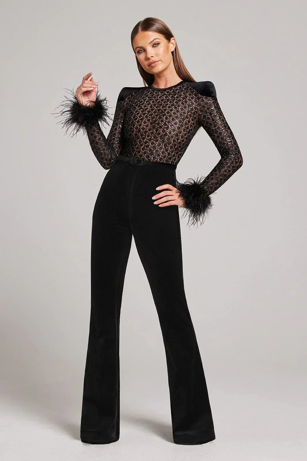 Mono elegante de fiesta con detalles de encaje y plumas